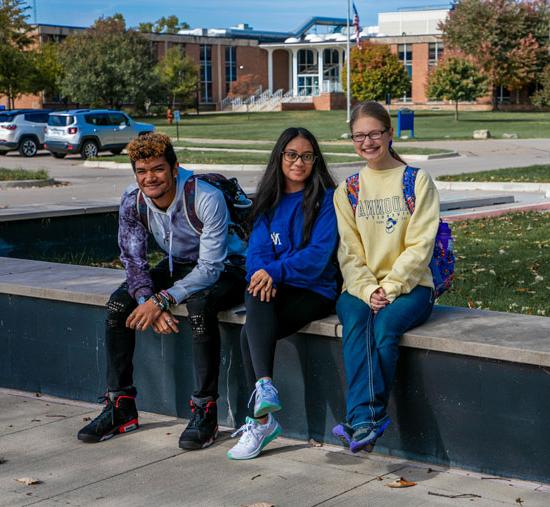 three students sitting by welcome center